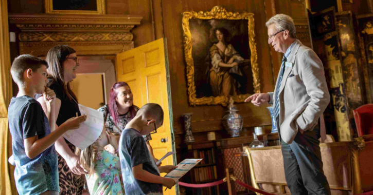 group of adults and children talking to tour guide on a guided tour of Raby Castle